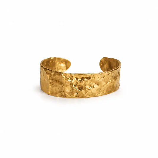 Gold color cuff bracelet on a white background