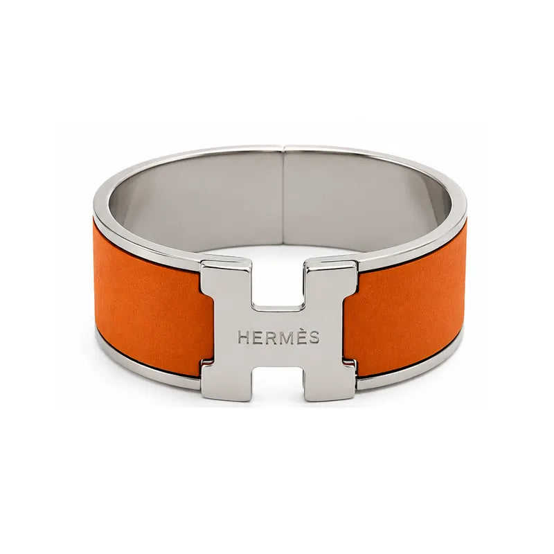 Hermes bracelet with orange band and silver clasp on a white background