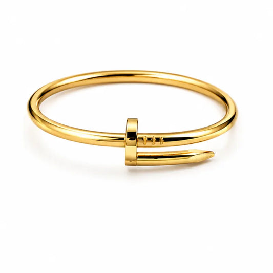 Gold bangle with a unique design on a white background