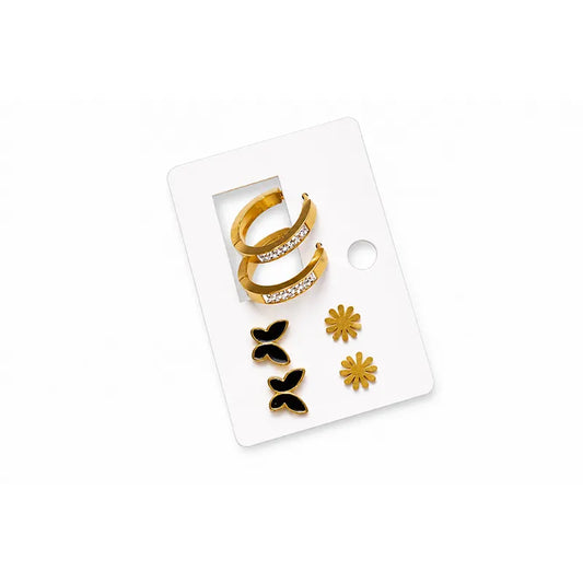 Set of gold and black earrings on a white card with a white background