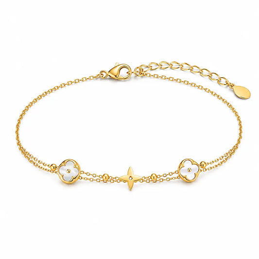 Gold bracelet with clover and star charms on a white background